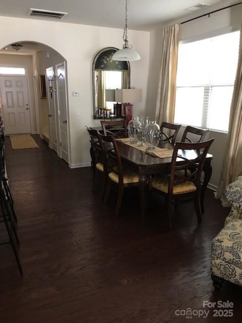 8039 Scarlet Oak Ter, Fort Mill, SC 29707 - dining area with arched walkways, dark wood finished floors, and baseboards