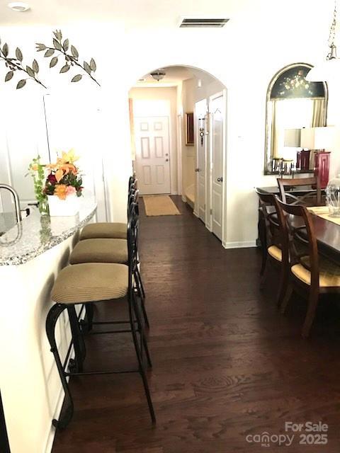 8039 Scarlet Oak Ter, Fort Mill, SC 29707 - dining space with arched walkways, dark wood-style floors, and baseboards