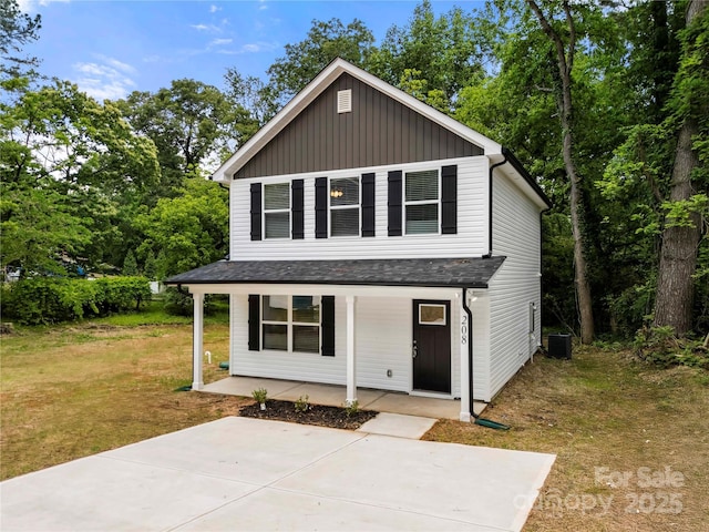 208 N Correll St, Landis, NC 28025 - traditional-style house with a porch, a front yard, board and batten siding, central AC unit, and view of scattered trees
