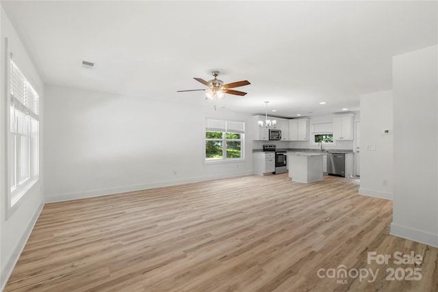 208 N Correll St, Landis, NC 28025 - unfurnished living room with a chandelier, a ceiling fan, baseboards, light wood-type flooring, and recessed lighting