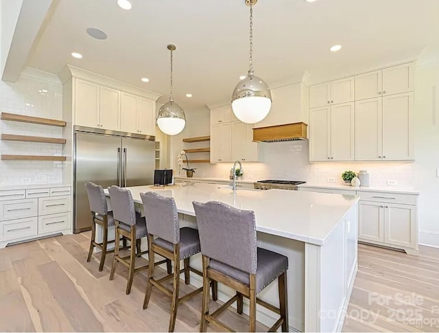7209 Alexander Rd Unit 3, Charlotte, NC 28270 - kitchen featuring open shelves, built in refrigerator, tasteful backsplash, an island with sink, and light countertops