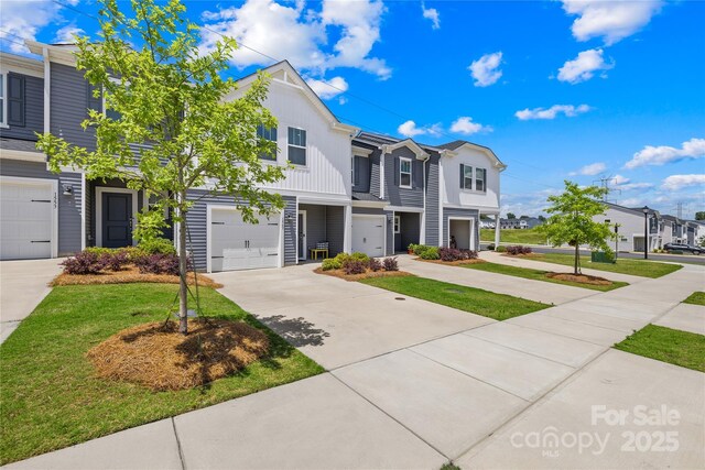 1563 Old Rivers Rd, Concord, NC 28027 - multi unit property featuring board and batten siding, an attached garage, driveway, a front yard, and a residential view