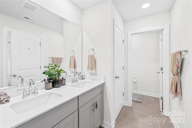 1563 Old Rivers Rd, Concord, NC 28027 - bathroom with double vanity, tile patterned floors, and baseboards