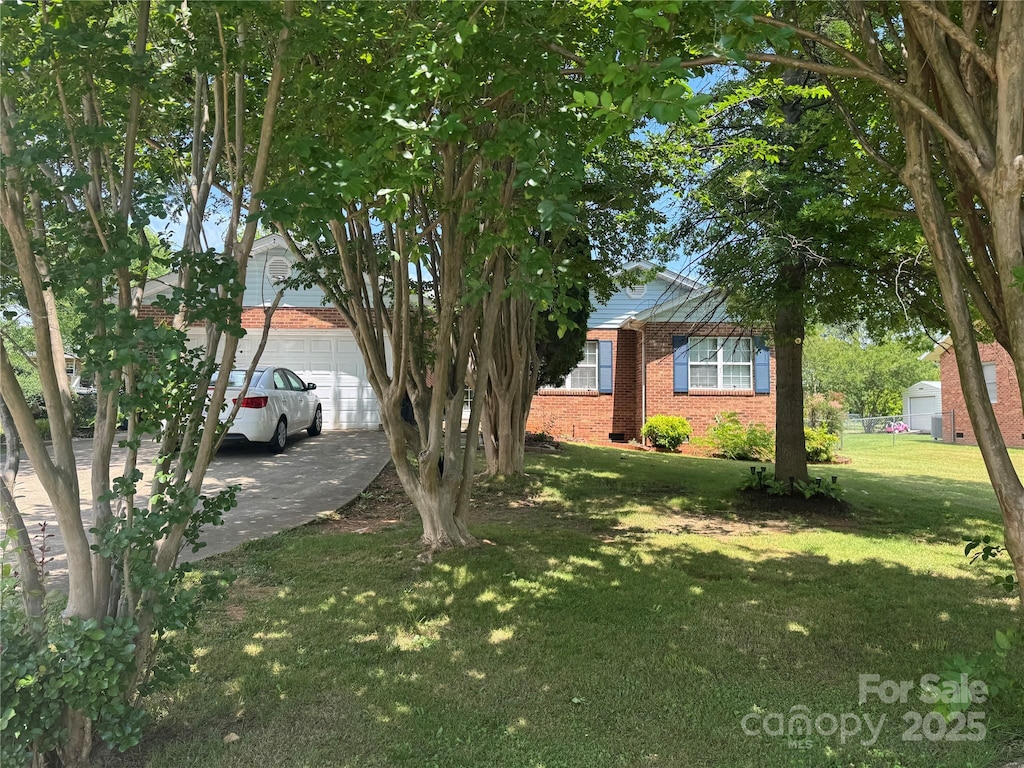 2104 2nd Ave NW, Hickory, NC 28601 - view of property hidden behind natural elements featuring brick siding, a front lawn, a garage, and driveway