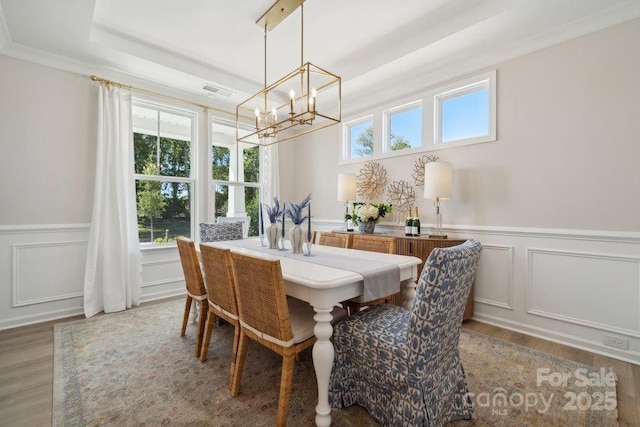 1431 Hubert Graham Way, Tega Cay, SC 29708 - dining room featuring a chandelier, wood finished floors, wainscoting, and a decorative wall