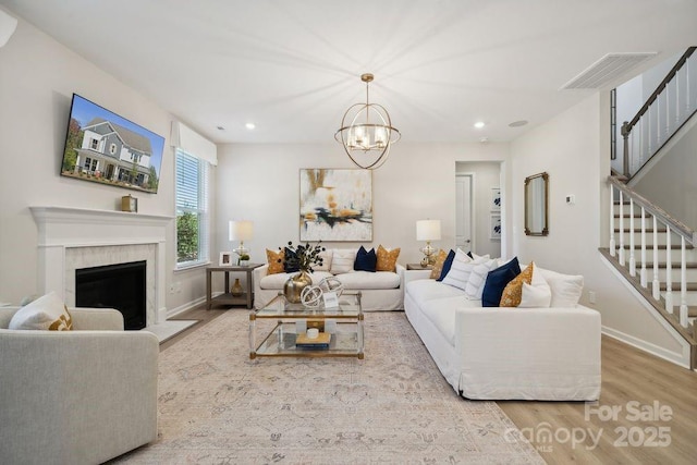 1431 Hubert Graham Way, Tega Cay, SC 29708 - living room featuring wood finished floors, stairway, a chandelier, baseboards, and recessed lighting