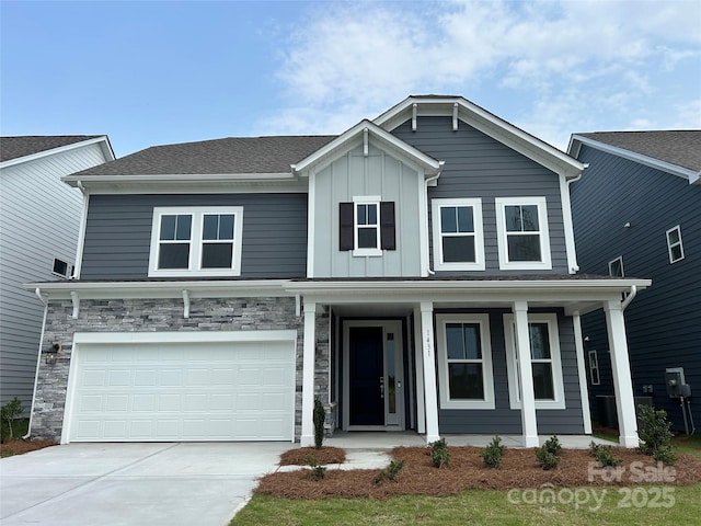 1431 Hubert Graham Way, Tega Cay, SC 29708 - view of front of home featuring a porch, driveway, board and batten siding, a garage, and stone siding