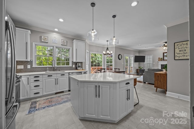 16028 Cranleigh Dr, Huntersville, NC 28078 - kitchen featuring a sink, appliances with stainless steel finishes, light countertops, a center island, and ornamental molding
