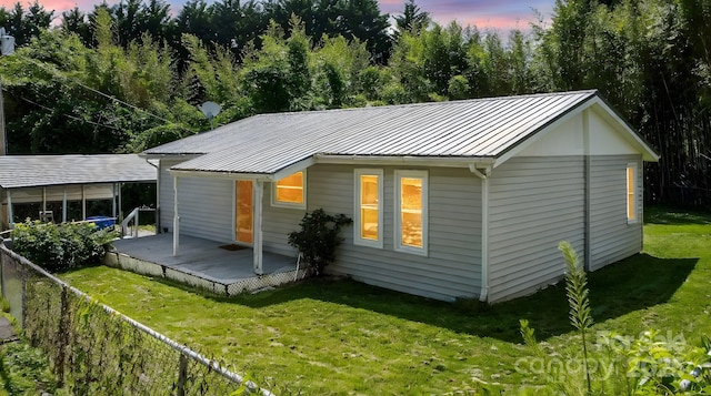 13 Rosscraggon Dr, Asheville, NC 28803 - property exterior at dusk featuring a metal roof, a standing seam roof, and a deck