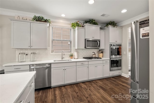 3009 Lydney Cir, Waxhaw, NC 28173 - kitchen featuring a sink, stainless steel appliances, ornamental molding, dark wood-style floors, and tasteful backsplash