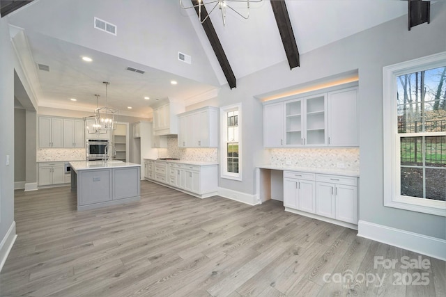 7215 Alexander Rd Unit 4, Charlotte, NC 28270 - kitchen featuring a chandelier, oven, light countertops, backsplash, and light wood-type flooring