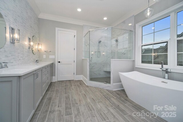 7215 Alexander Rd Unit 4, Charlotte, NC 28270 - bathroom featuring double vanity, a freestanding tub, a marble finish shower, wood finished floors, and ornamental molding
