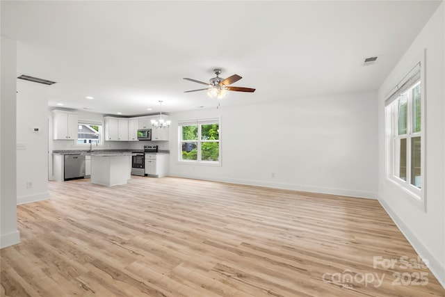 210 N Correll St, Landis, NC 28025 - unfurnished living room with a chandelier, plenty of natural light, light wood finished floors, baseboards, and recessed lighting