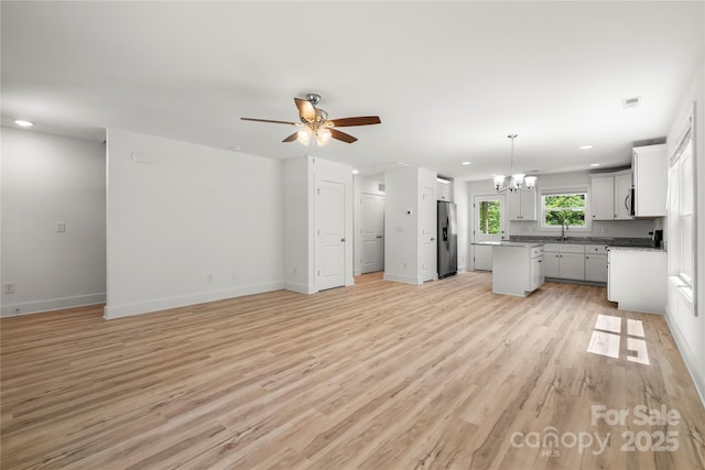 210 N Correll St, Landis, NC 28025 - unfurnished living room with a chandelier, light wood-style floors, ceiling fan, recessed lighting, and baseboards