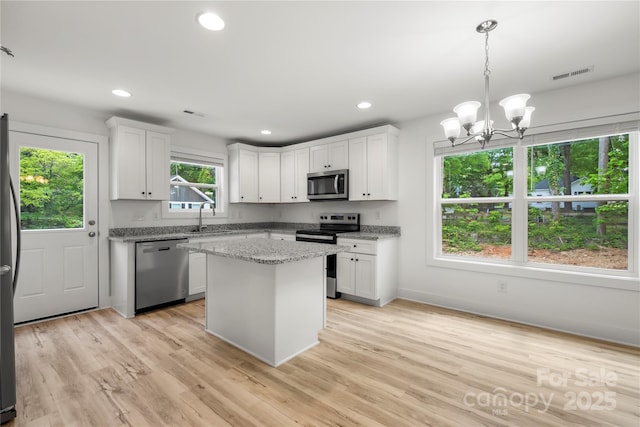 210 N Correll St, Landis, NC 28025 - kitchen with appliances with stainless steel finishes, a sink, a chandelier, light wood-style flooring, and white cabinets