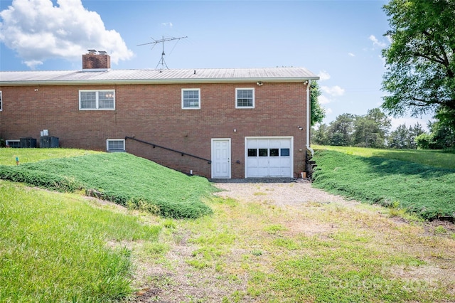 765 York Institute Rd, Hiddenite, NC 28636 - rear view of property featuring a garage, a chimney, brick siding, and driveway