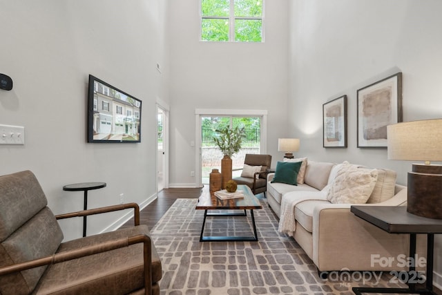 3034 Finchborough Ct Unit 233, Charlotte, NC 28269 - living area featuring plenty of natural light, wood finished floors, a high ceiling, and baseboards