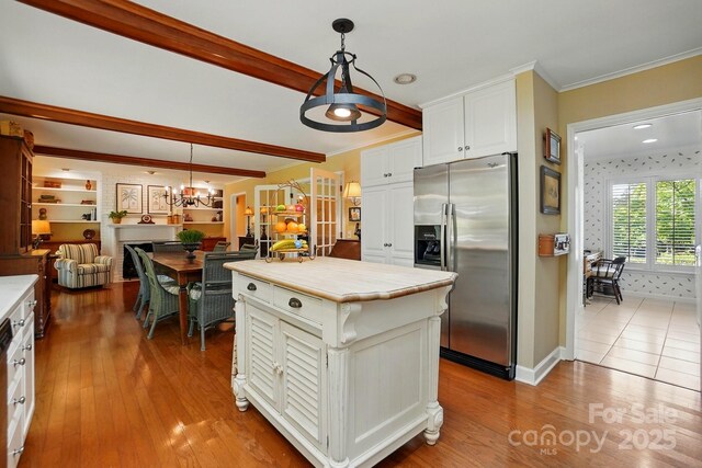 308 Odell St, Kannapolis, NC 28083 - kitchen featuring stainless steel fridge, a chandelier, white cabinets, decorative light fixtures, and light wood-style flooring
