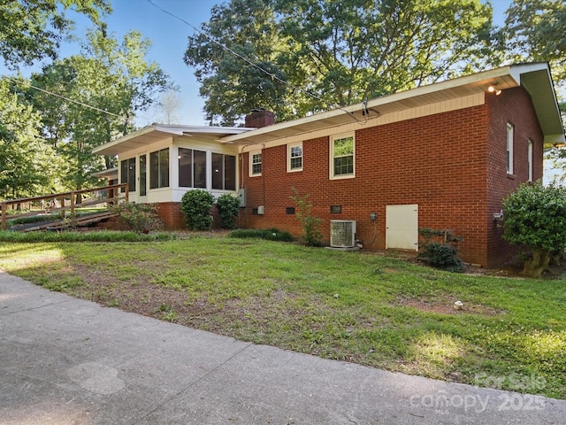 2216 Griffith Rd, Monroe, NC 28112 - view of property exterior featuring a sunroom, a yard, brick siding, and central air condition unit