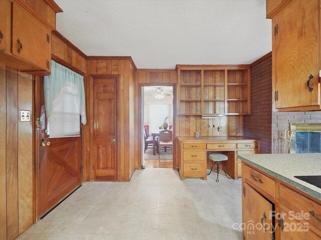 2216 Griffith Rd, Monroe, NC 28112 - office area featuring crown molding, wood walls, a brick fireplace, and light floors
