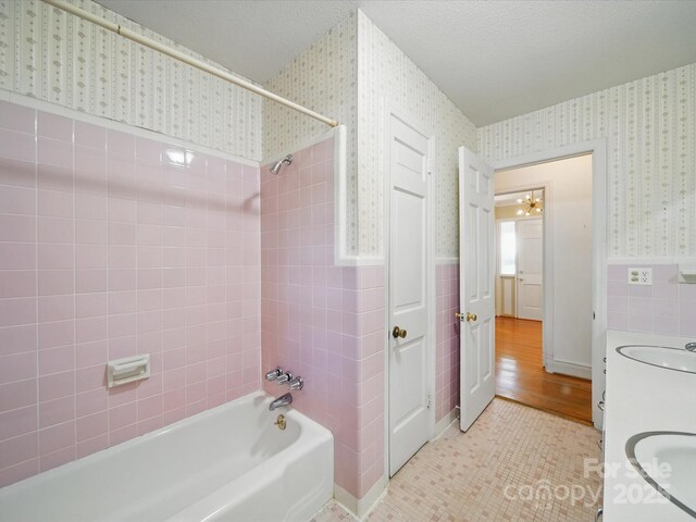 2216 Griffith Rd, Monroe, NC 28112 - full bath with wallpapered walls, a wainscoted wall, shower / bathtub combination, vanity, and tile walls