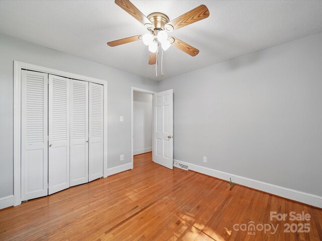 2216 Griffith Rd, Monroe, NC 28112 - unfurnished bedroom with light wood-style flooring, baseboards, a closet, and a ceiling fan