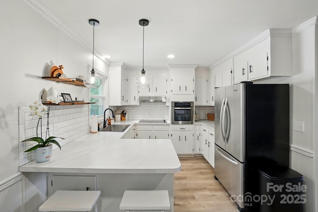103 W Sunset Dr, Locust, NC 28097 - kitchen with a sink, appliances with stainless steel finishes, a peninsula, under cabinet range hood, and tasteful backsplash
