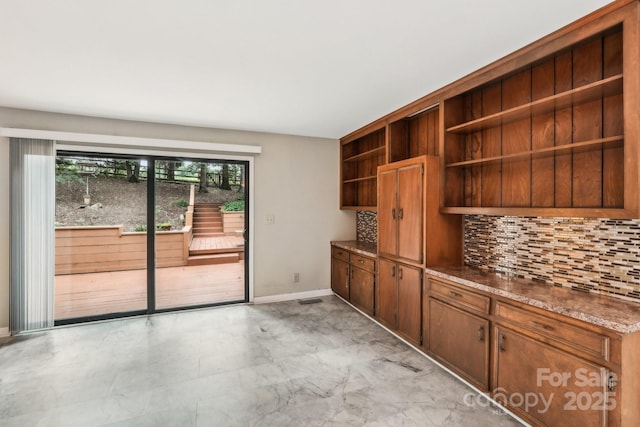 8117 Rising Meadow Rd, Charlotte, NC 28277 - kitchen with open shelves, tasteful backsplash, light marble finish floors, baseboards, and brown cabinets