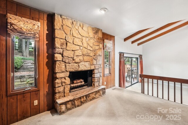 8117 Rising Meadow Rd, Charlotte, NC 28277 - unfurnished living room with carpet flooring, a fireplace, beam ceiling, and wood walls
