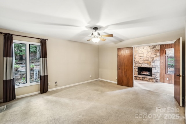 8117 Rising Meadow Rd, Charlotte, NC 28277 - unfurnished living room with ceiling fan, carpet, baseboards, and a stone fireplace