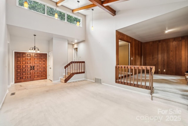 8117 Rising Meadow Rd, Charlotte, NC 28277 - carpeted entryway featuring stairway, a high ceiling, baseboards, beamed ceiling, and wooden walls