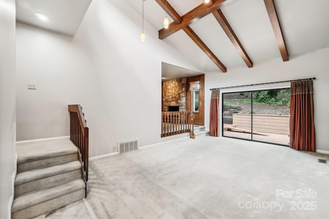 8117 Rising Meadow Rd, Charlotte, NC 28277 - unfurnished living room featuring carpet, beamed ceiling, stairway, high vaulted ceiling, and a stone fireplace