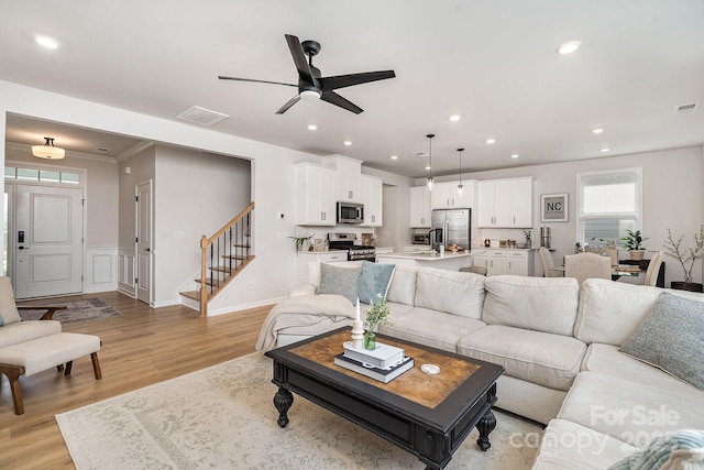 16018 River Tree Ln, Charlotte, NC 28278 - living area with stairs, light wood-style flooring, recessed lighting, ceiling fan, and a wainscoted wall