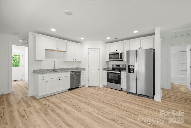 212 N Correll St, Landis, NC 28025 - kitchen featuring stainless steel appliances, light wood finished floors, a sink, white cabinets, and recessed lighting