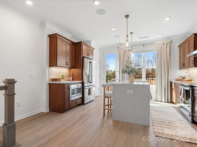 5508 Swaling St, Charlotte, NC 28217 - kitchen featuring appliances with stainless steel finishes, light wood-type flooring, decorative backsplash, a center island, and crown molding