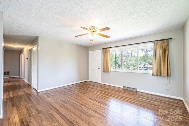 1515 Fairway Acres Rd, Lenoir, NC 28645 - empty room with wood finished floors, a ceiling fan, and a textured ceiling