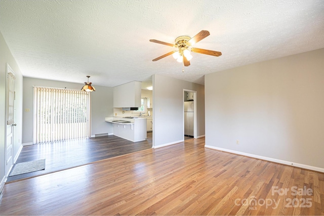 1515 Fairway Acres Rd, Lenoir, NC 28645 - unfurnished living room with a ceiling fan, light wood-type flooring, and a textured ceiling
