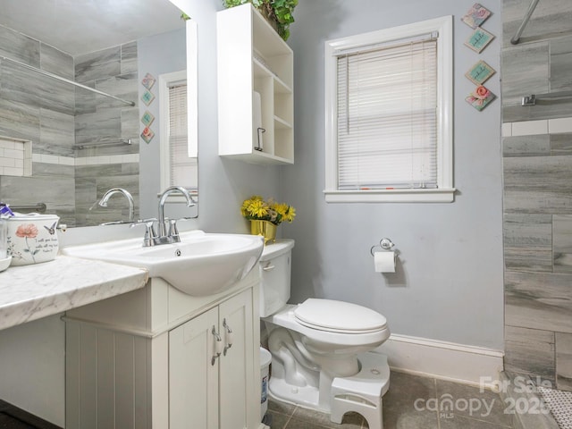 5629 Ruth Dr, Charlotte, NC 28215 - bathroom with a tile shower, toilet, vanity, baseboards, and tile patterned flooring