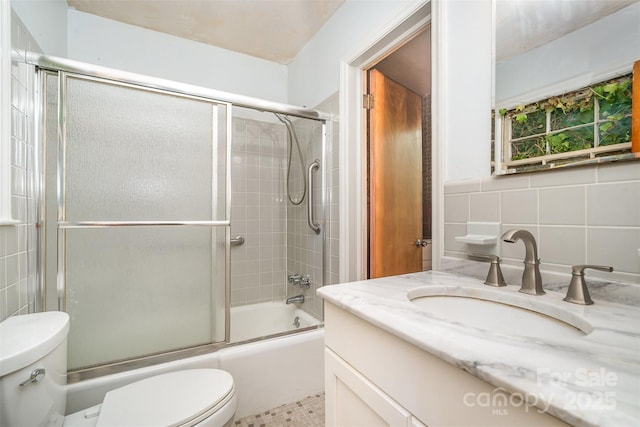 3526 Craig Ave, Charlotte, NC 28211 - bathroom featuring toilet, vanity, combined bath / shower with glass door, and tile walls