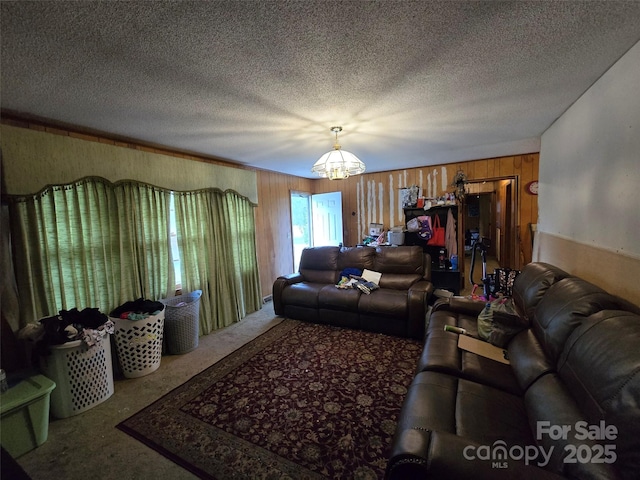 116 E Graves St, Candor, NC 27229 - carpeted living room with wood walls, a chandelier, and a textured ceiling