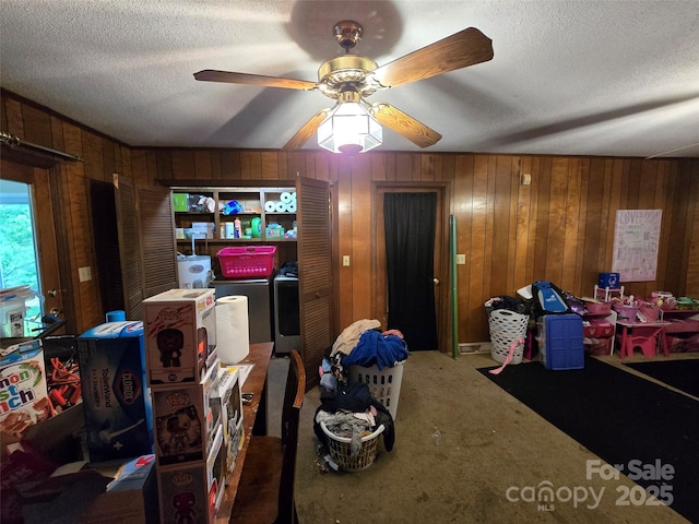 116 E Graves St, Candor, NC 27229 - carpeted living area with washing machine and dryer, a textured ceiling, a ceiling fan, and wood walls