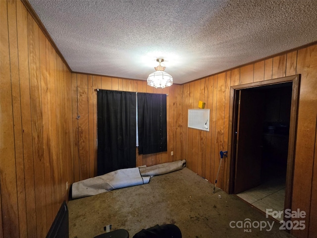 116 E Graves St, Candor, NC 27229 - carpeted dining room with wooden walls, a chandelier, a textured ceiling, and crown molding