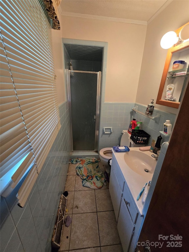 116 E Graves St, Candor, NC 27229 - bathroom featuring tile walls, tile patterned floors, a shower stall, vanity, and wainscoting