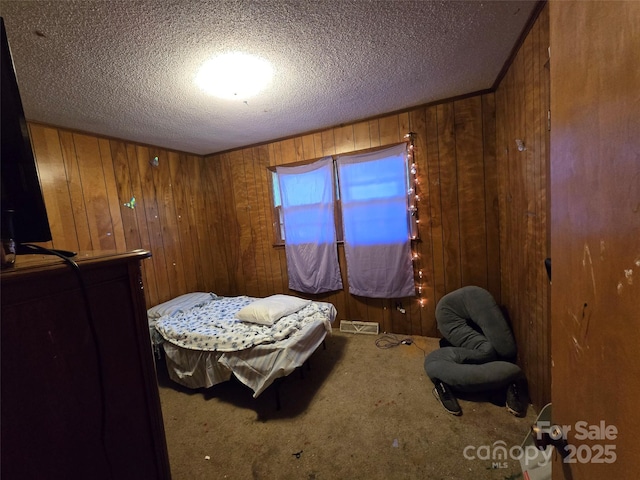 116 E Graves St, Candor, NC 27229 - carpeted bedroom with wood walls and a textured ceiling