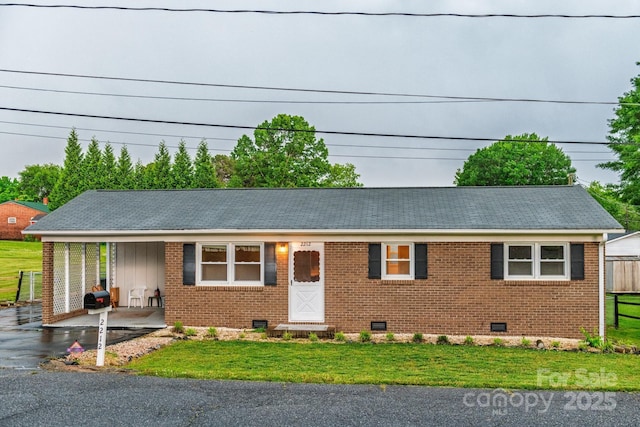single story home featuring crawl space, a front yard, board and batten siding, and brick siding