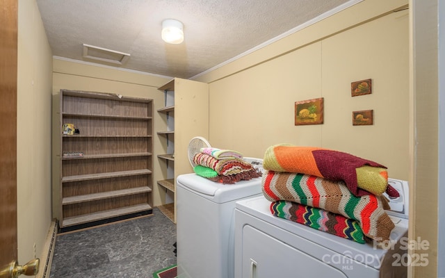 washroom featuring washing machine and clothes dryer, attic access, ornamental molding, and a textured ceiling
