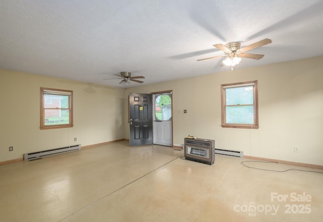 spare room with a baseboard heating unit, a ceiling fan, baseboards, and a textured ceiling