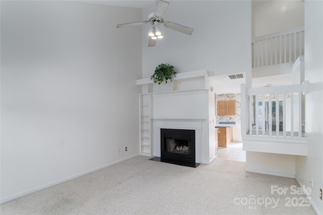 9006 Four Mile Creek Rd, Charlotte, NC 28277 - unfurnished living room featuring carpet flooring, a high ceiling, ceiling fan, baseboards, and a fireplace with flush hearth