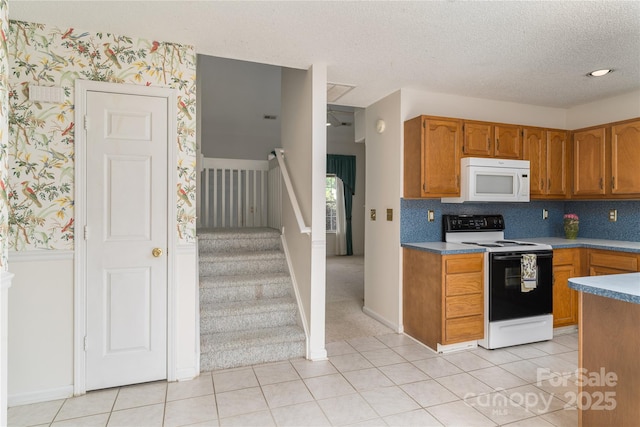 9006 Four Mile Creek Rd, Charlotte, NC 28277 - kitchen featuring electric range oven, white microwave, wallpapered walls, brown cabinets, and a textured ceiling