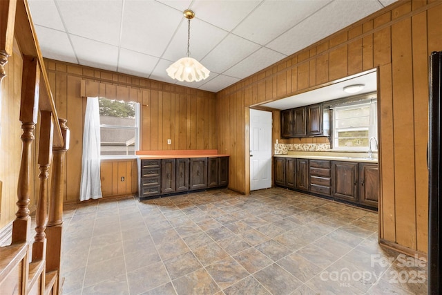 217 S Highland St, Gastonia, NC 28052 - kitchen with plenty of natural light, wooden walls, light countertops, pendant lighting, and a sink